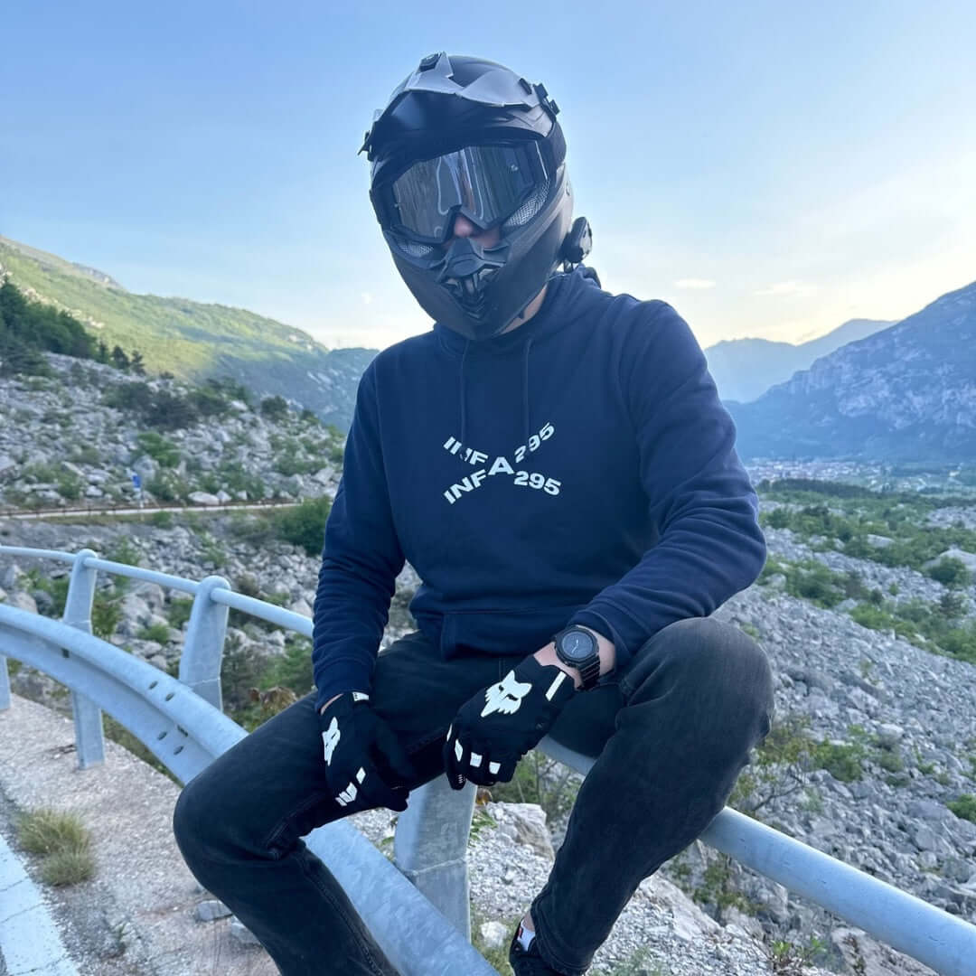  Motorradfahrer im INFA 295 BIKELIFE Hoodie sitzt auf einem Gelände am Bergpass in einer malerischen Landschaft.